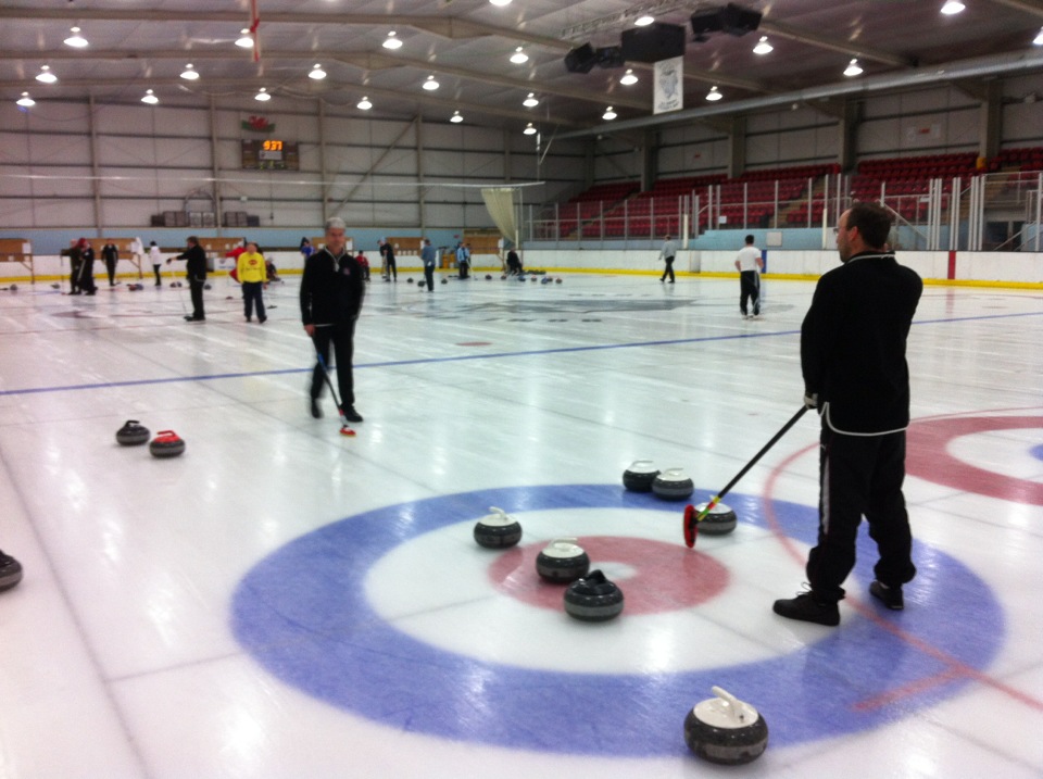 Photograph of Deeside ice rink, with two players conferring by the stones about which shot to play